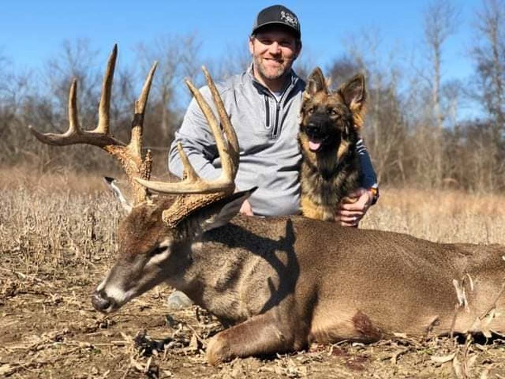 Hunter and his German Shepherd posing with a whitetail buck